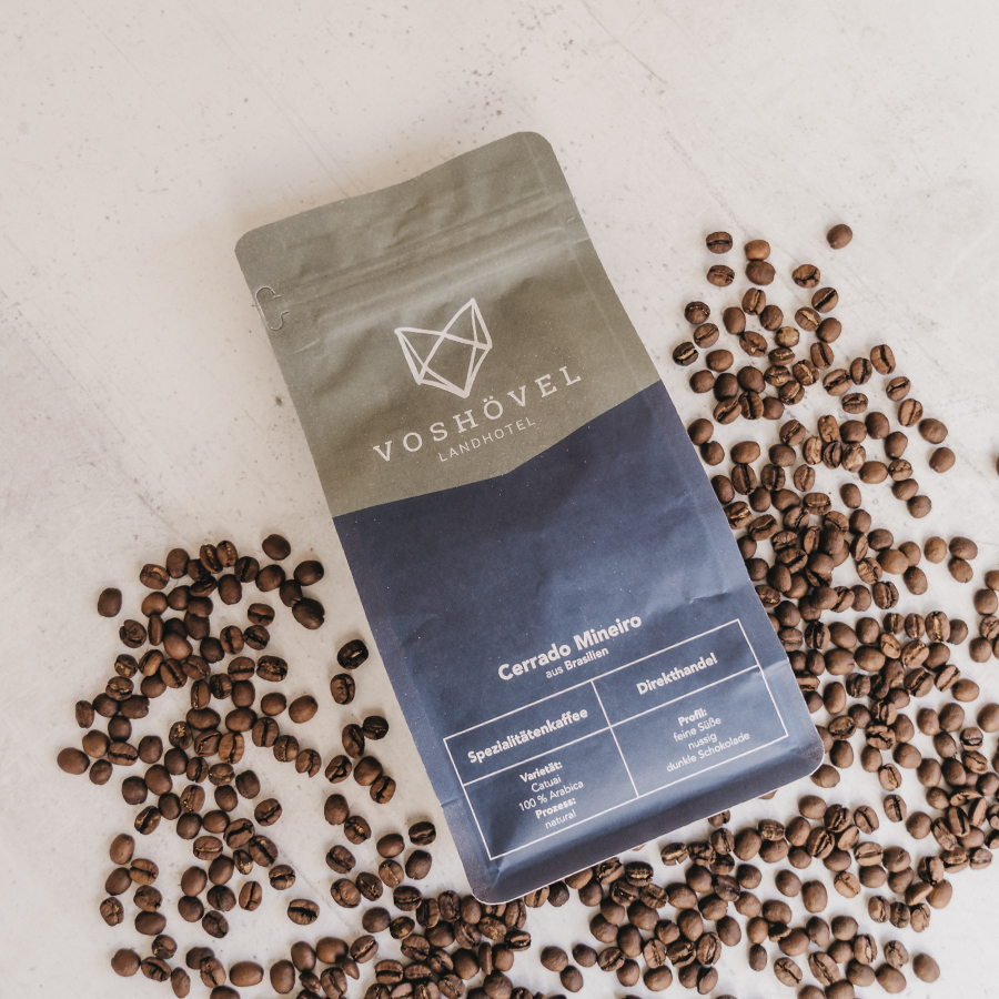 Packung mit Kaffeebohnen liegt zwischen Kaffeebohnen