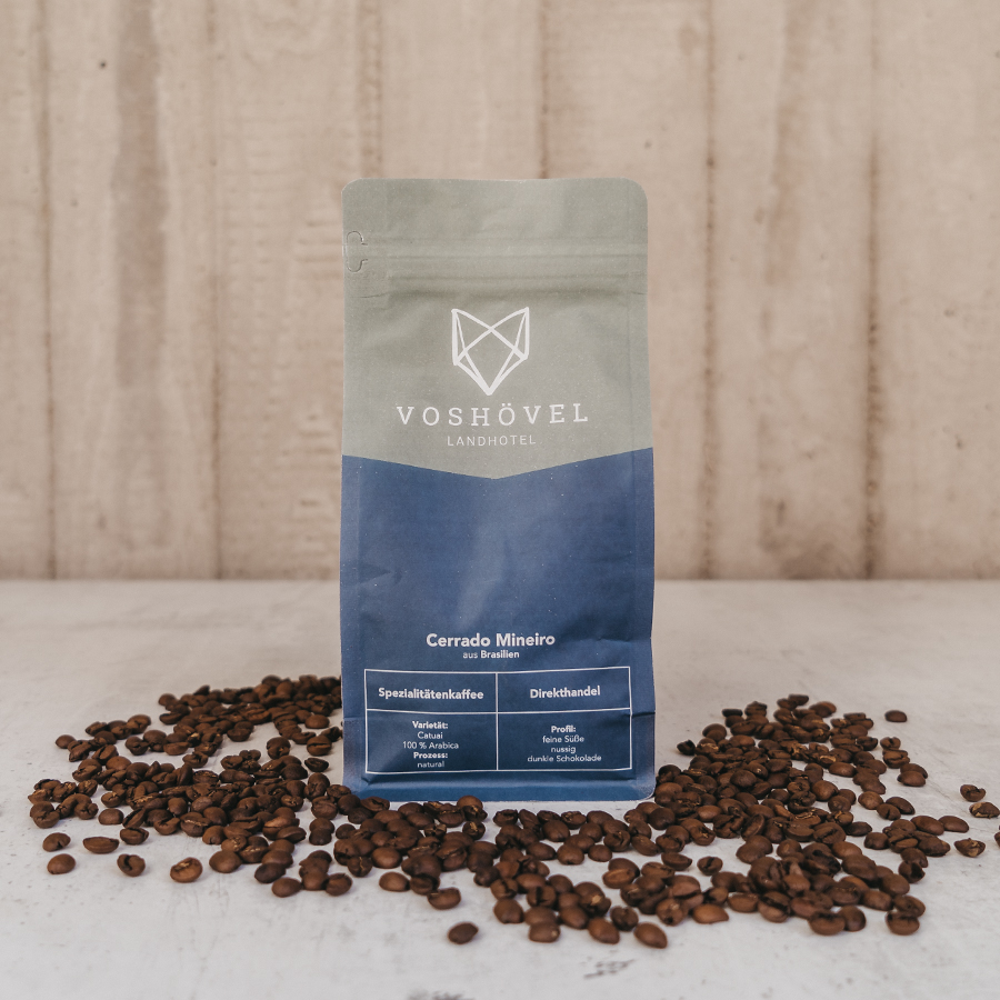 Packung mit Kaffeebohnen steht zwischen Kaffeebohnen