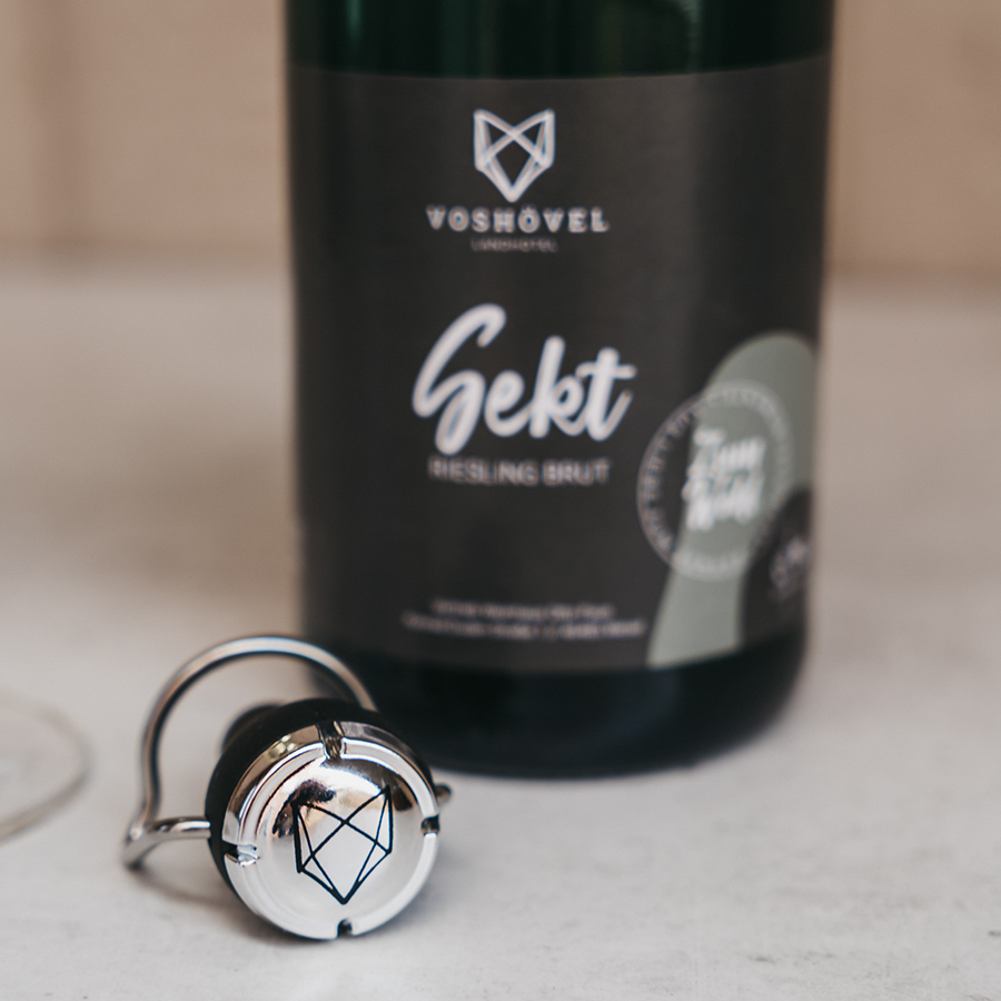 Voshövel Flaschenverschluss in Schwarz/Silber vor einer Flasche